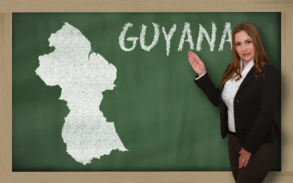 Teacher showing map of guyana on blackboard — Stock Photo, Image