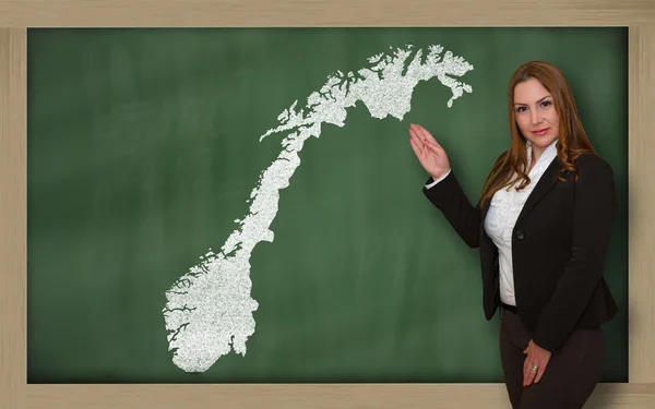 Teacher showing map of norway on blackboard — Stock Photo, Image