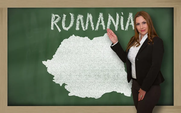 Teacher showing map of romania on blackboard — Stock Photo, Image