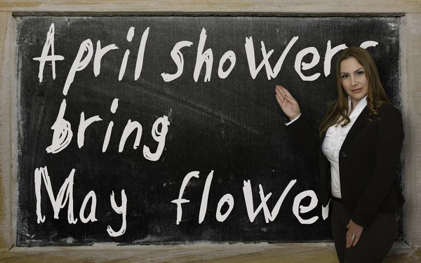 Profesor mostrando lluvias de abril traer flores de mayo en pizarra — Foto de Stock