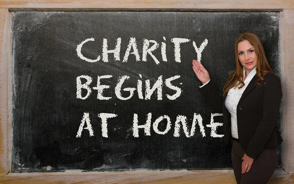 Lehrerin zeigt Wohltätigkeit beginnt zu Hause an Tafel — Stockfoto