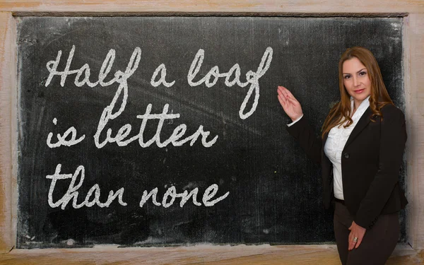 Teacher showing Half a loaf is better than none on blackboard — Stock Photo, Image