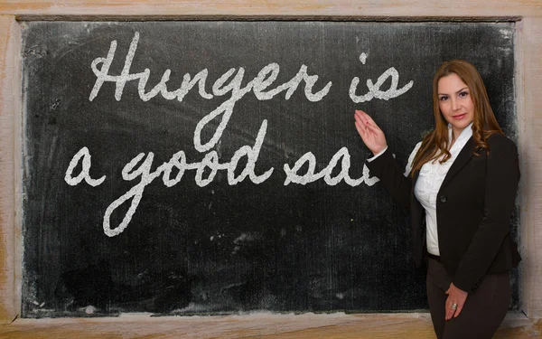 Lehrer zeigt, dass Hunger eine gute Soße an der Tafel ist — Stockfoto