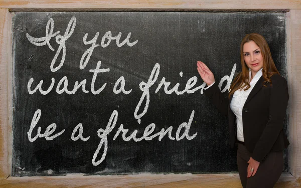 Teacher showing If you want a friend, be a friend on blackboard — Stock Photo, Image