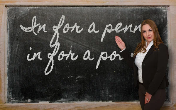 Teacher showing In for a penny, in for a pound on blackboard — Stock Photo, Image