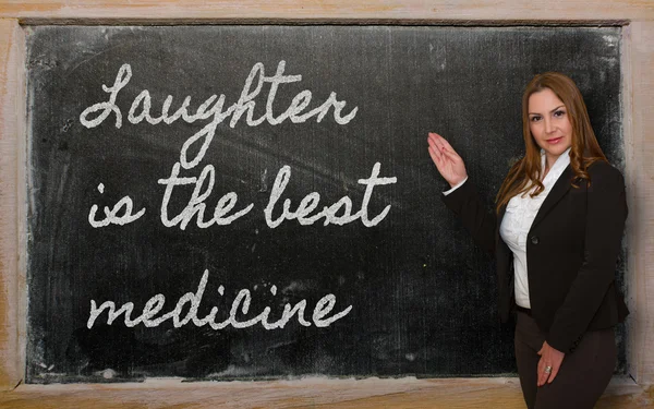 Professeur montrant rire est le meilleur médicament sur tableau noir — Photo