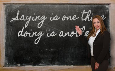 öğretmen gösteren söyleyerek bir şey, başka bir blackbo yapıyor