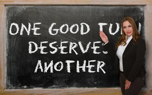Öğretmen bir iyilik gösteren başka bir kara tahta üzerinde hak ediyor. — Stok fotoğraf