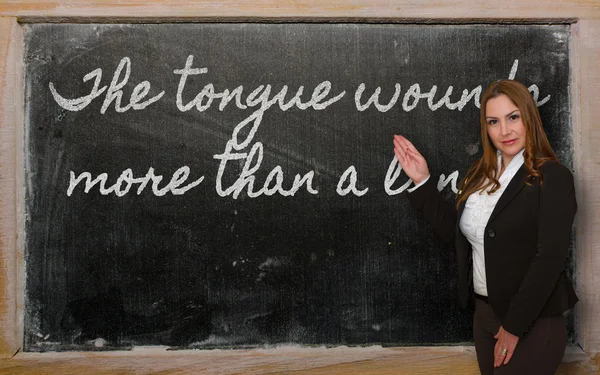 Läraren visar tungan sårar mer än en lans på blackboar — Stockfoto