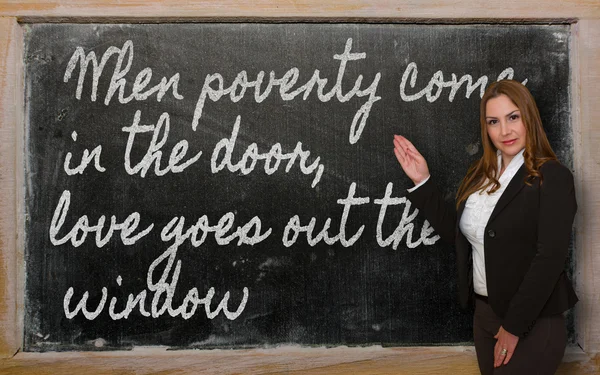 Teacher showing When poverty come in the door, love goes out the — Stock Photo, Image