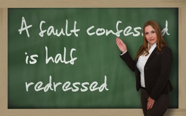 Teacher showing A fault confessed is half redressed on blackboar clipart