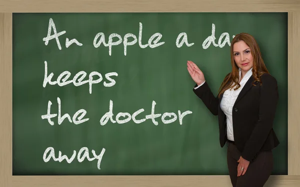 老师显示一天一个苹果让医生走上 blackboa — 图库照片