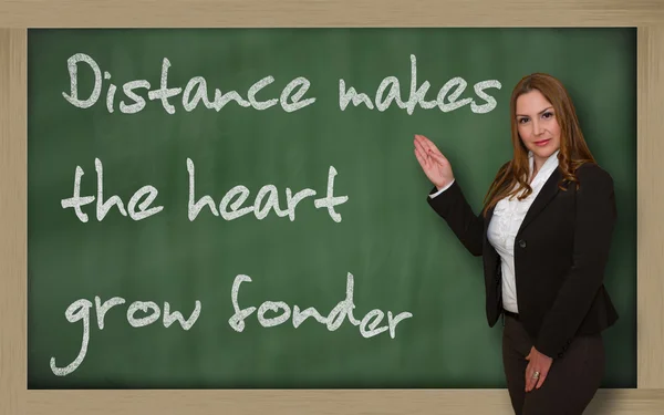 Insegnante che mostra Distanza fa crescere il cuore più affezionato al blackboa — Foto Stock