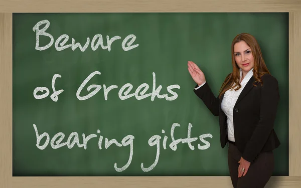 Profesor mostrando Cuidado con los griegos que llevan regalos en la pizarra —  Fotos de Stock