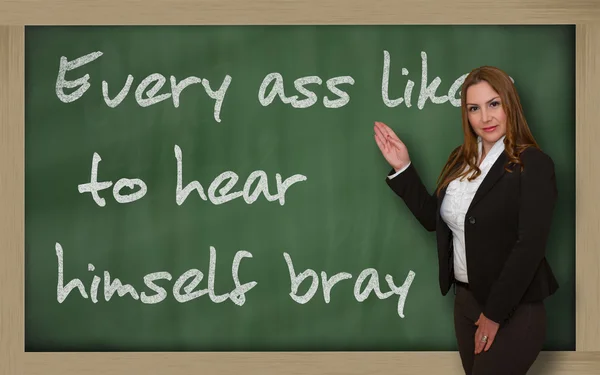 Teacher showing Every ass likes to hear himself bray on blackboa — Stock Photo, Image