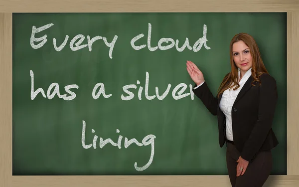 Insegnante che mostra ogni nuvola ha un lato positivo sulla lavagna Immagine Stock