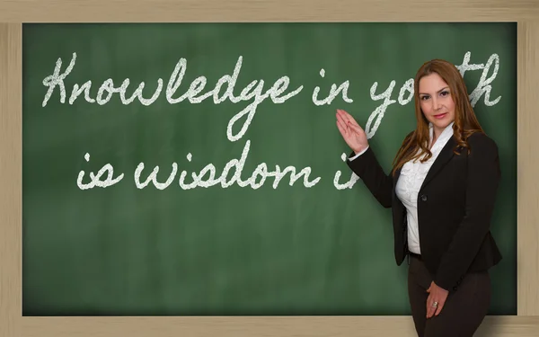 Teacher showing Knowledge in youth is wisdom in age on blackboar — Stock Photo, Image