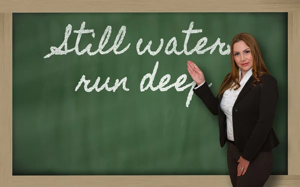 Insegnante mostrando acque tranquille correre in profondità sulla lavagna — Foto Stock