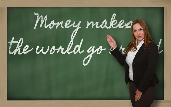 Teacher showing Money makes the world go around on blackboard — Stock Photo, Image