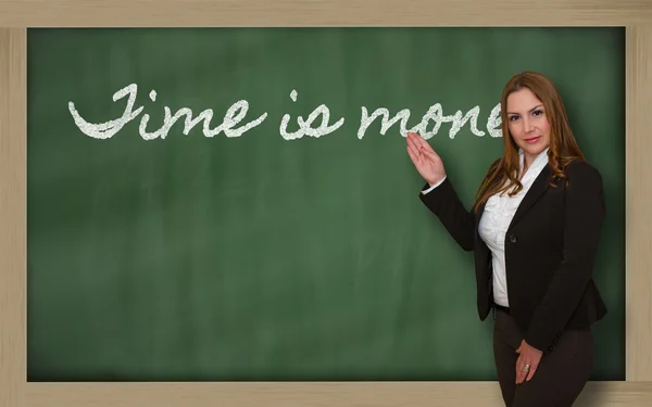 Teacher showing Time is money on blackboard — Stock Photo, Image