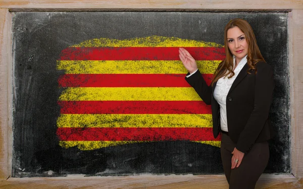 Учитель показывает флаг Каталонии на доске для презентации — стоковое фото