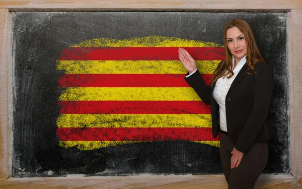 先生は黒板にはプレゼンテーションのフラグ ofcatalonia を示す — ストック写真