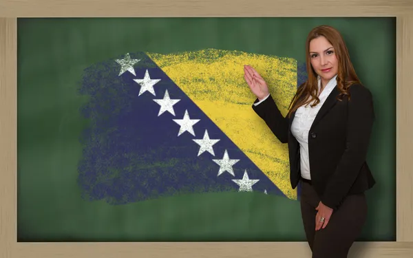 Teacher showing flag ofbosnia herzegovina on blackboard for pres — Stock Photo, Image