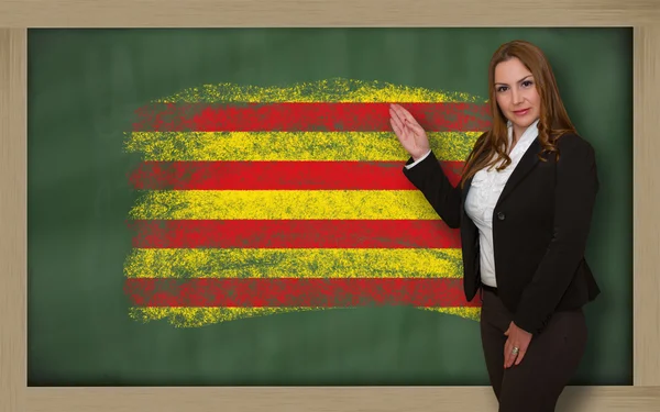 Lehrerin zeigt Flagge Kataloniens auf Tafel zur Präsentation — Stockfoto