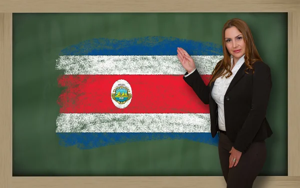 Lehrerin zeigt Flagge von Costarica auf Tafel zur Präsentation — Stockfoto