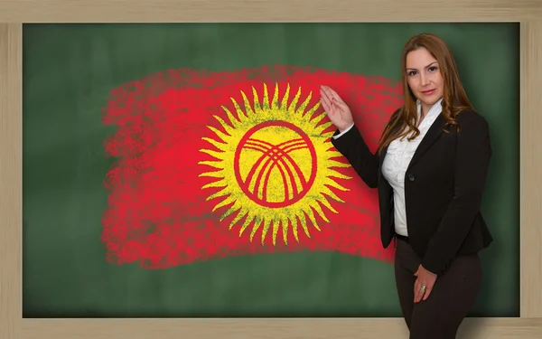 Učitel ukazuje vlajky ofkirghizstan na tabuli pro presentatio — Stock fotografie