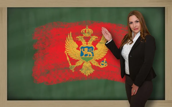 Учитель показывает флаг Черногории на доске для презентации — стоковое фото
