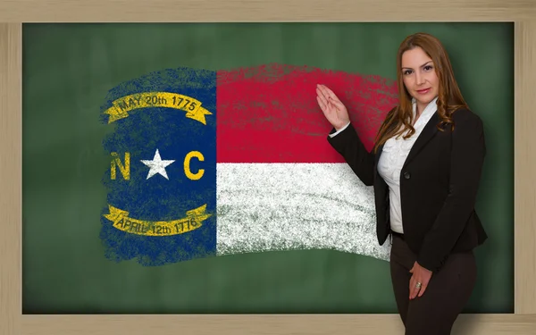 Teacher showing flag of north carolina on blackboard for presenta — Stock Photo, Image