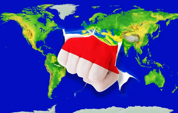 Puño en color bandera nacional de indonesia perforando mapa del mundo — Foto de Stock