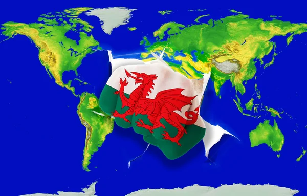 Punho na cor bandeira nacional de wales perfurando mapa do mundo — Fotografia de Stock
