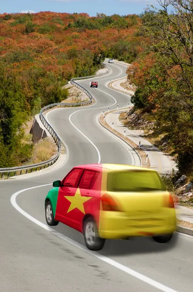 Car on road in national flag of cameroon colors — Stock Photo, Image