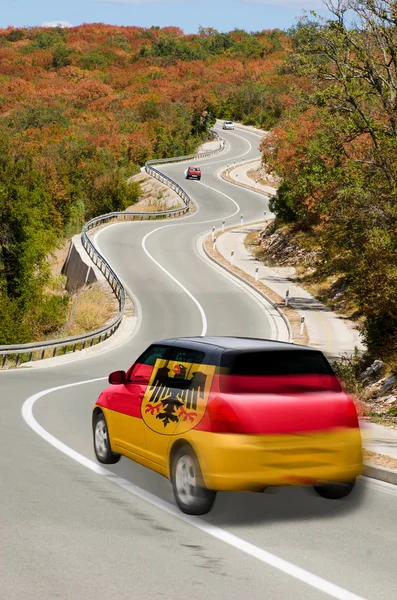 Car on road in national flag of germany colors — Stock Photo, Image