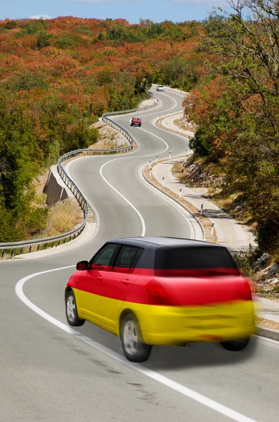 Автомобиль на дороге под национальным флагом Германии цветов — стоковое фото