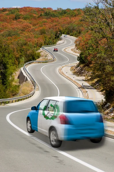 Car on road in national flag of guatemala colors — Stock Photo, Image