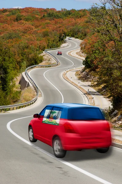 Car on road in national flag of haiti colors — Stock Photo, Image