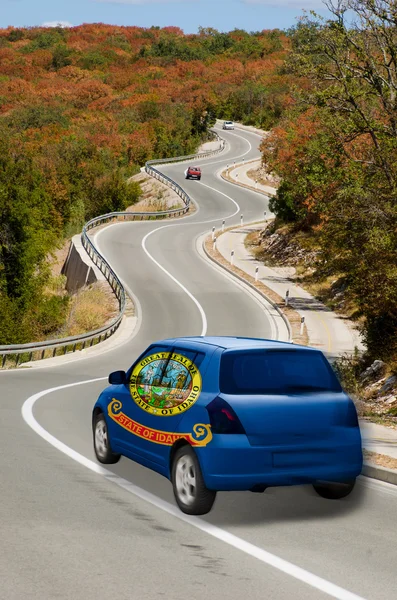 Auto su strada in bandiera di stato americano di colori idaho — Foto Stock