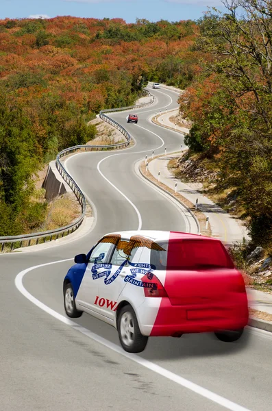 Car on road in flag of american state of iowa colors — Stock Photo, Image