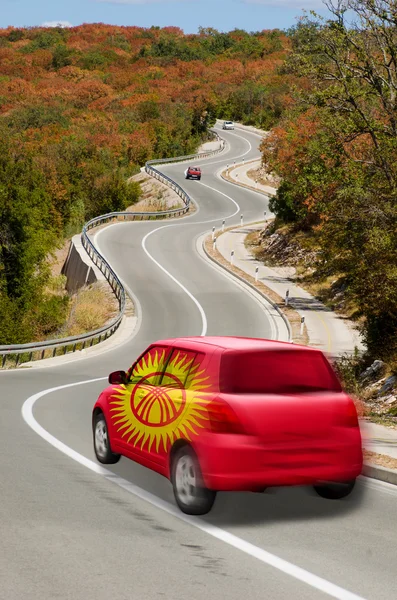 Samochód na drodze flagi narodowej w Kirgizji kolorów — Zdjęcie stockowe