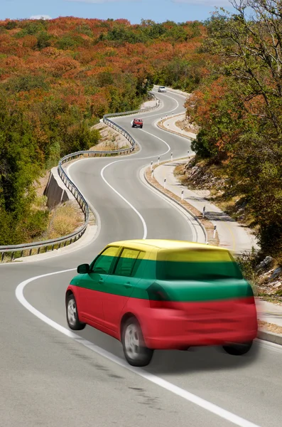 Car on road in national flag of lithuania colors — Stock Photo, Image