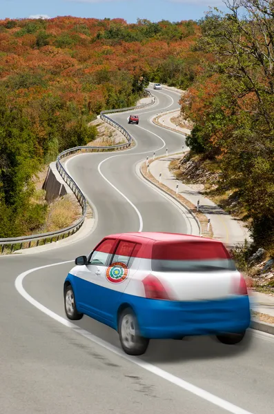 Автомобиль на дороге в национальном флаге Парагвая цветов — стоковое фото