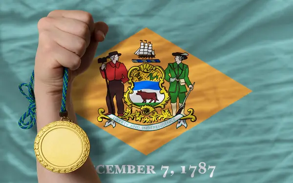 Gold medal for sport and flag of american state of delaware — Stockfoto