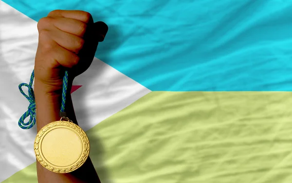 Золотая медаль за спорт и национальный флаг Джибути — стоковое фото