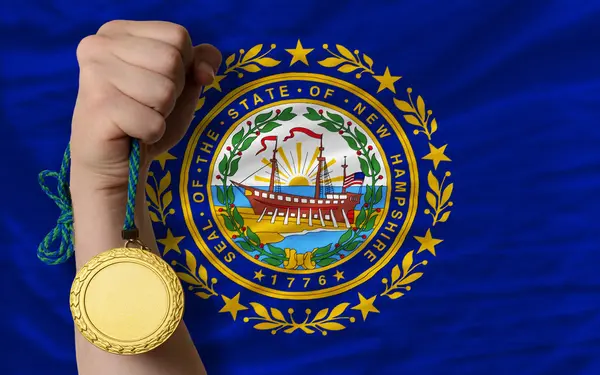 Zlatá medaile pro sport a vlajka amerického státu new Hampshire na jižním — Stock fotografie