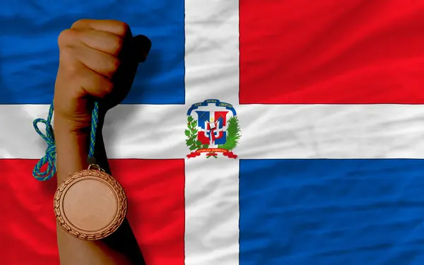 Бронзовая медаль за спорт и национальный флаг Доминиканской Республики — стоковое фото