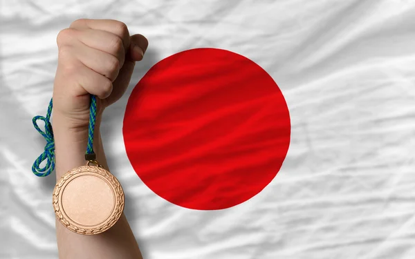 Medalha de bronze para esporte e bandeira nacional do japão — Fotografia de Stock