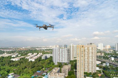 Şehir merkezinde kameralı ve mavi gökyüzüyle uçan profesyonel bir insansız hava aracının hava görüntüsü, dijital teknoloji kavramı. Elektronik bir cihaz. Küçük bir uçak veya uçak.